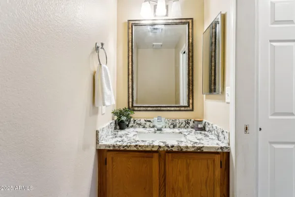 a bathroom with a granite countertop sink and a mirror