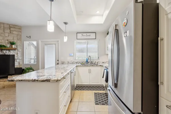 a bathroom with a granite countertop sink and a large mirror