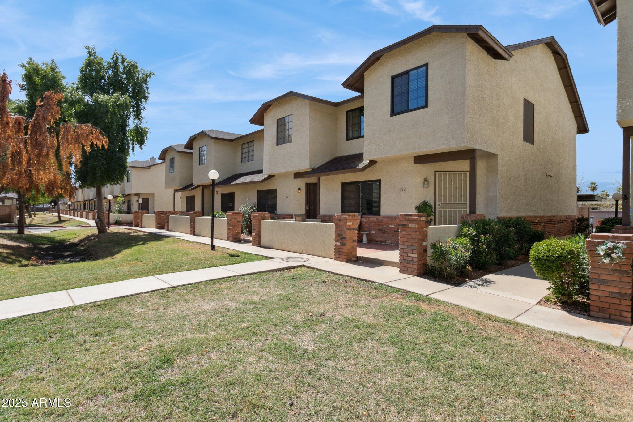 170 East Guadalupe Road, Unit 152 Gilbert, AZ 85234 - Photo 26 of 29 a view of a white house with a yard and plants