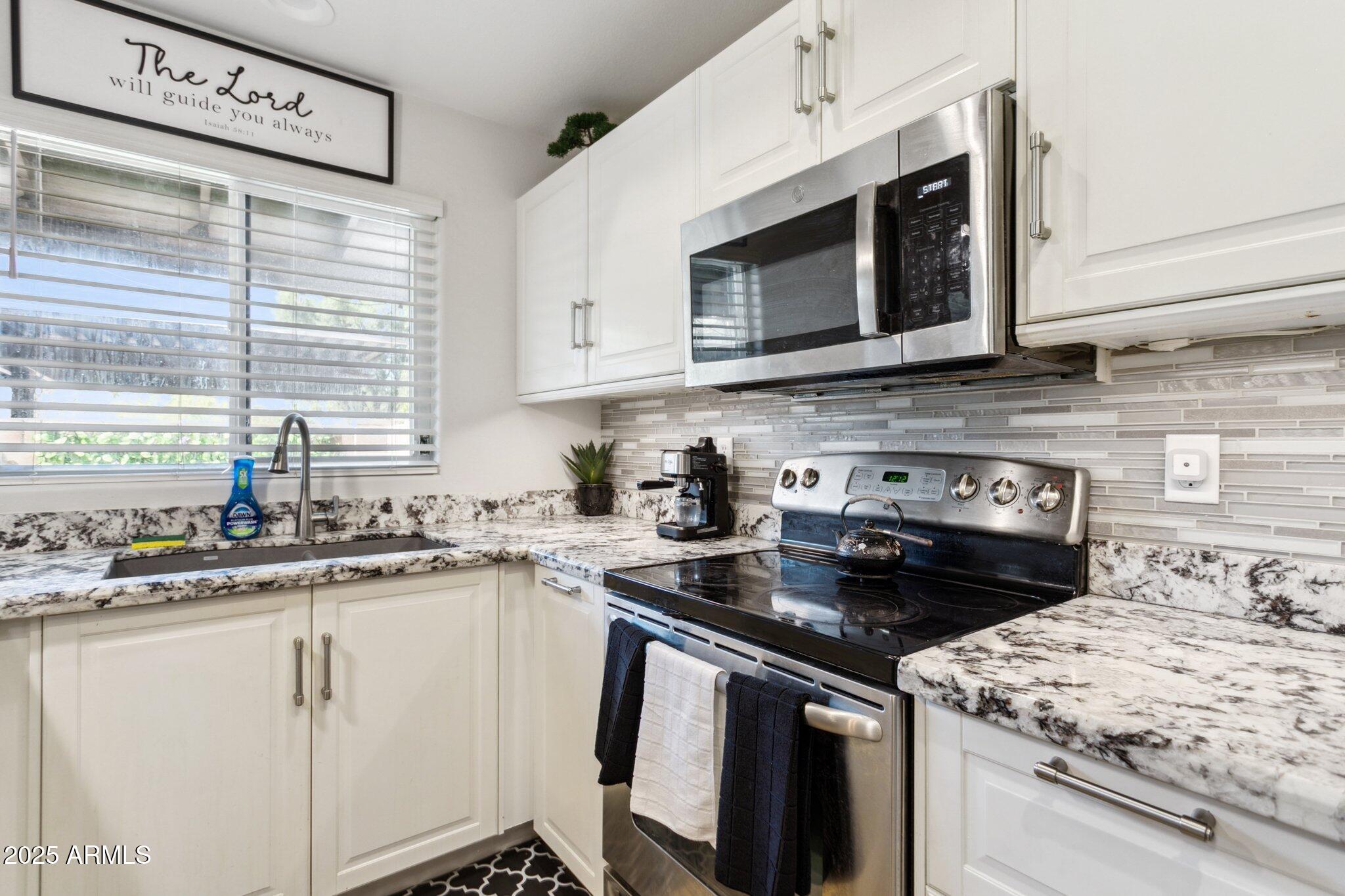 170 East Guadalupe Road, Unit 152 Gilbert, AZ 85234 - Photo 3 of 29 a kitchen with a stove and a microwave