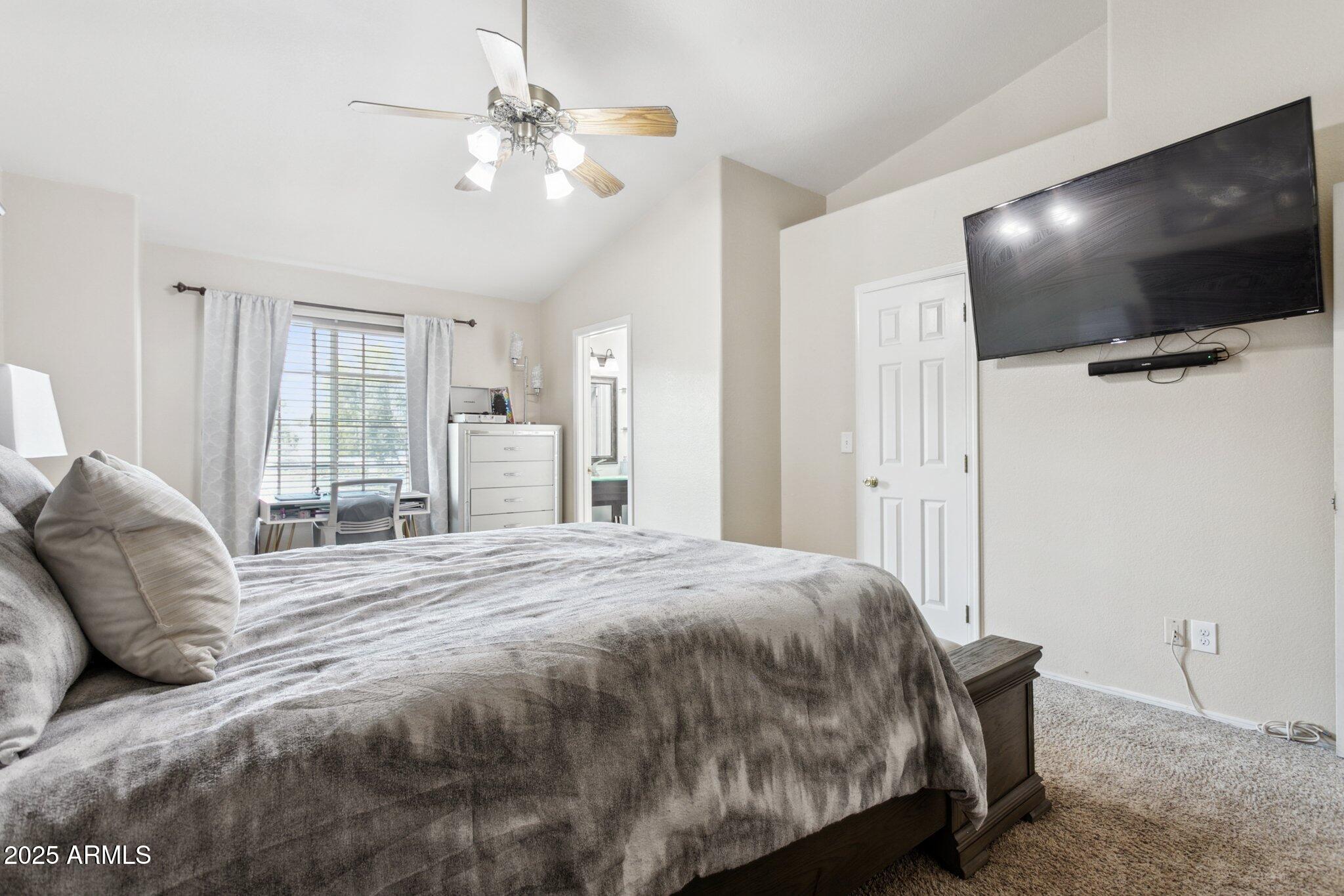 170 East Guadalupe Road, Unit 152 Gilbert, AZ 85234 - Photo 5 of 29 a spacious bedroom with a bed and a flat screen tv