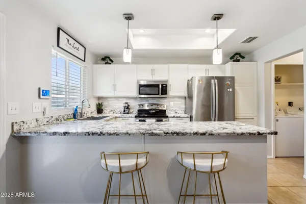 a kitchen with stainless steel appliances granite countertop a sink a stove counter space and cabinets