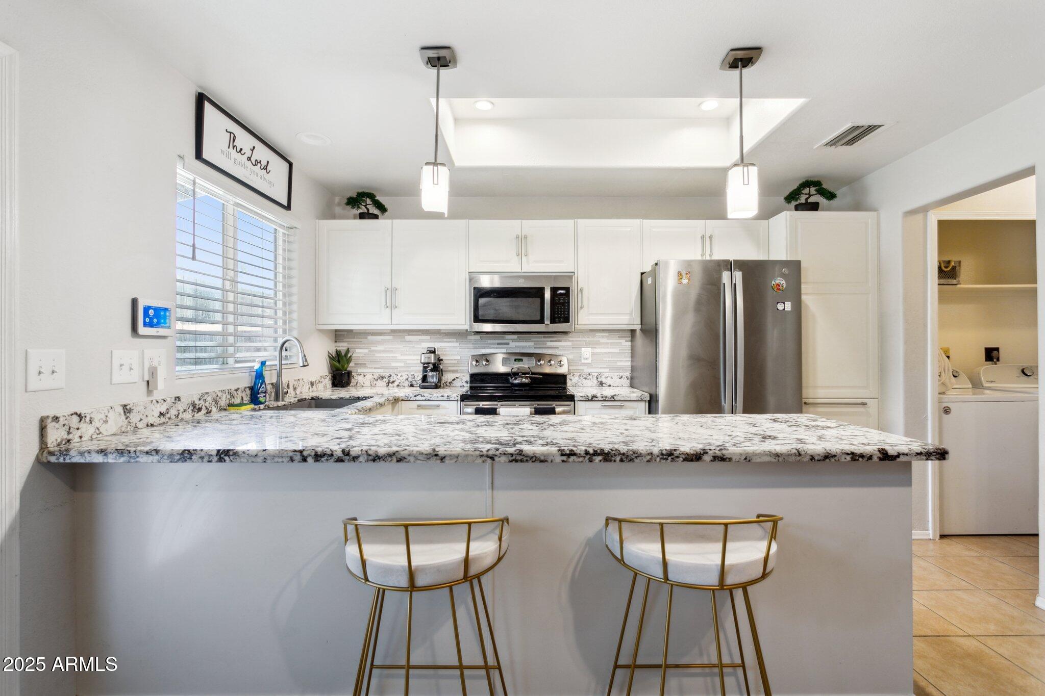 170 East Guadalupe Road, Unit 152 Gilbert, AZ 85234 - Photo 10 of 29 a kitchen with stainless steel appliances granite countertop a sink a stove counter space and cabinets