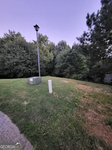 a view of a green field with a tree in the background