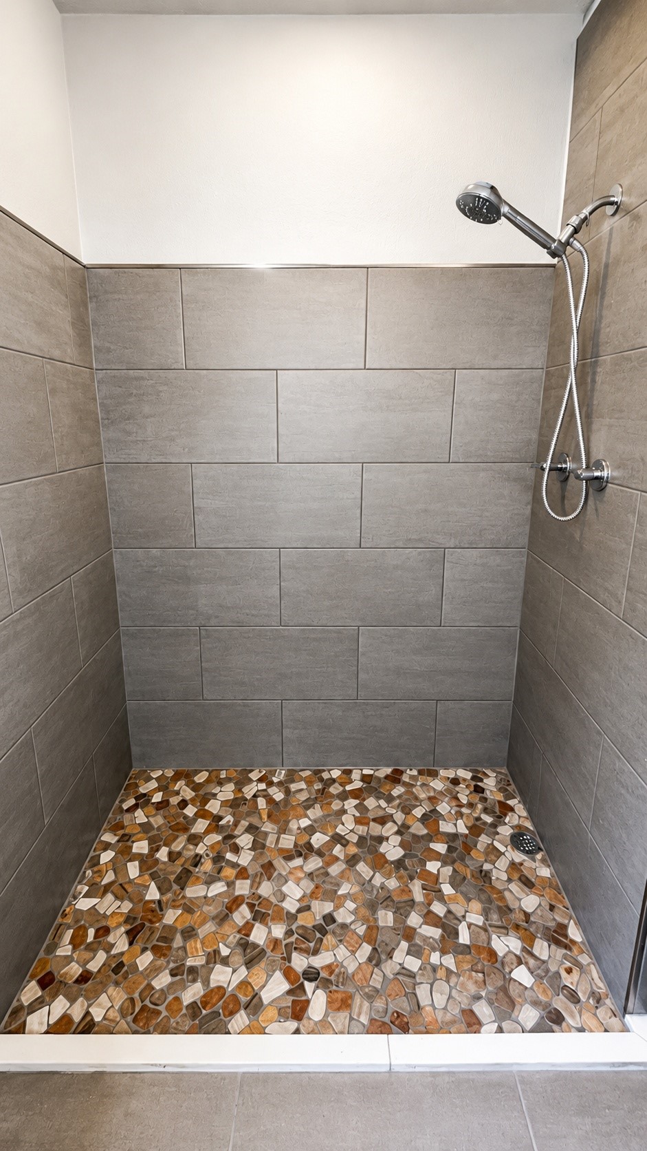 7622 Azalea Street Houston, TX 77023 - Photo 4 of 10 Custom shower with large-format tile surround and decorative pebble-style shower flooring.