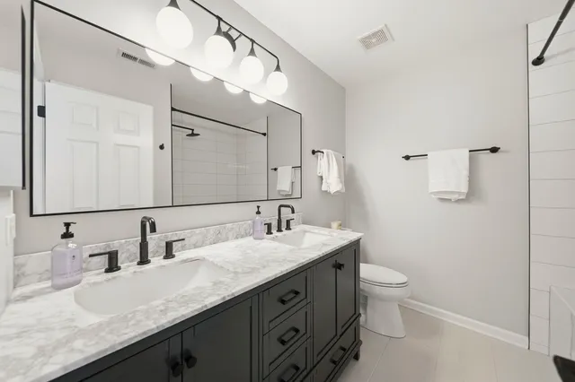 a bathroom with a granite countertop sink a toilet and a mirror