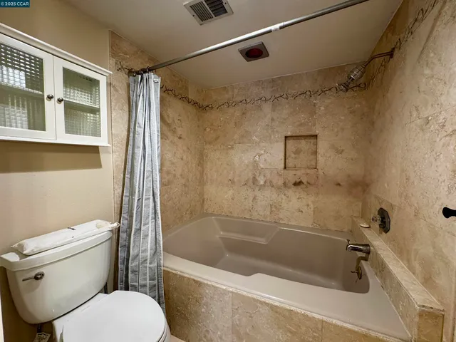 a bath room with a toilet and a bath tub