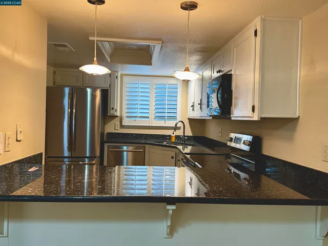 a kitchen with kitchen island a counter space a sink and appliances