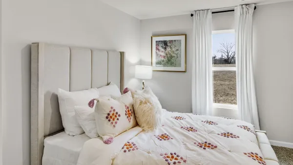 a bedroom with a bed and a mirror on dresser