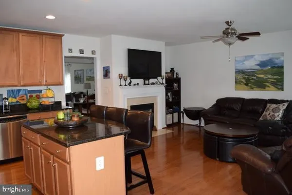 a kitchen with a stove a sink dishwasher a dining table and chair with wooden floor