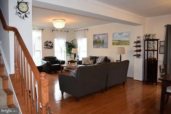 a living room with furniture a lamp and wooden floor