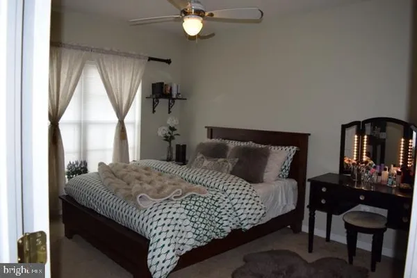 a bedroom with a bed and dresser with mirror