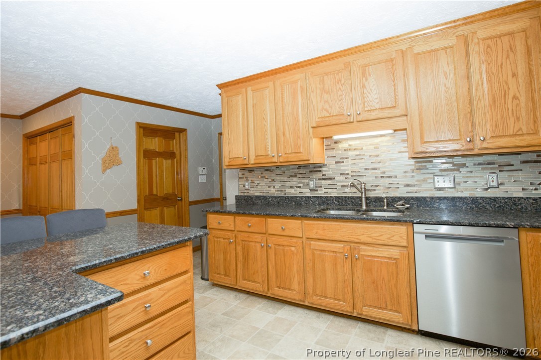 7815 Shuttle Road Fayetteville, NC 28311 - Photo 15 of 50 a kitchen with granite countertop wooden cabinets and a granite counter tops