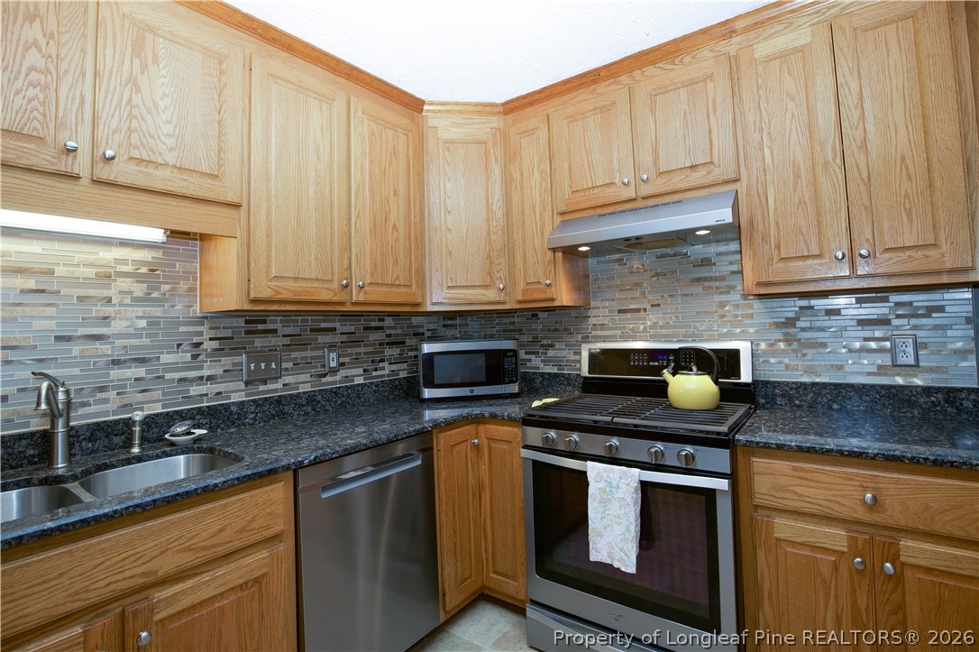7815 Shuttle Road Fayetteville, NC 28311 - Photo 16 of 50 a kitchen with stainless steel appliances granite countertop a sink a stove and a microwave