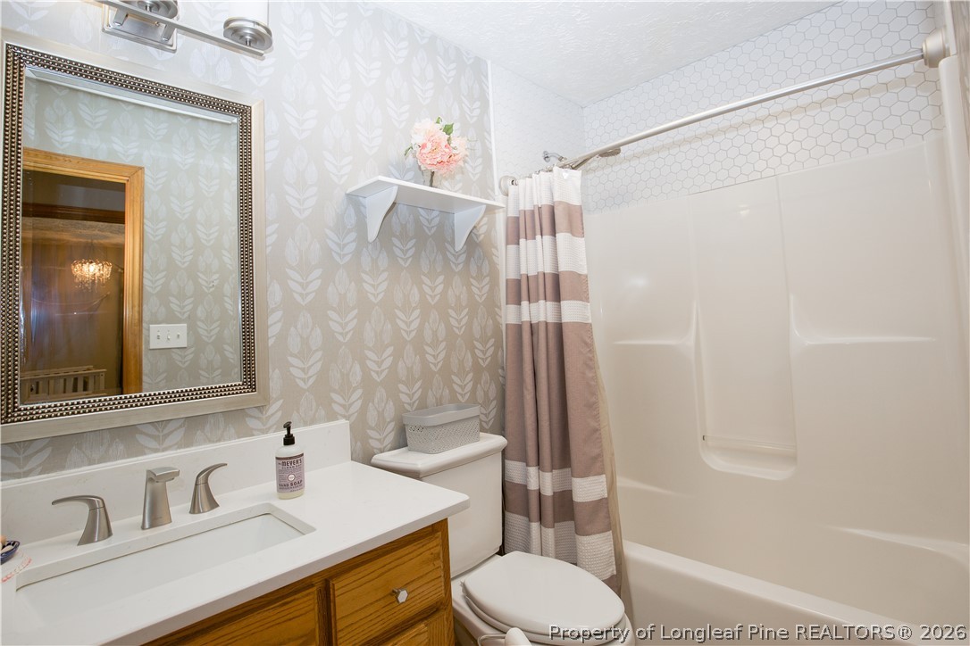 7815 Shuttle Road Fayetteville, NC 28311 - Photo 27 of 50 a bathroom with a sink toilet and shower