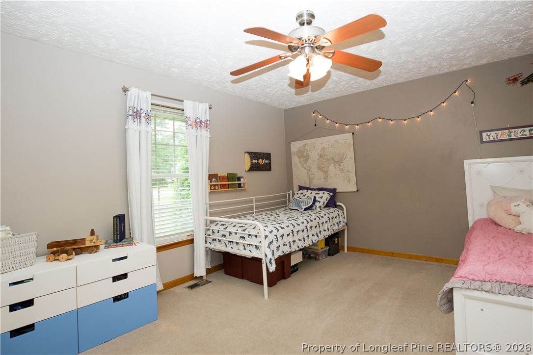7815 Shuttle Road Fayetteville, NC 28311 - Photo 28 of 50 a bedroom with a bed and a chandelier