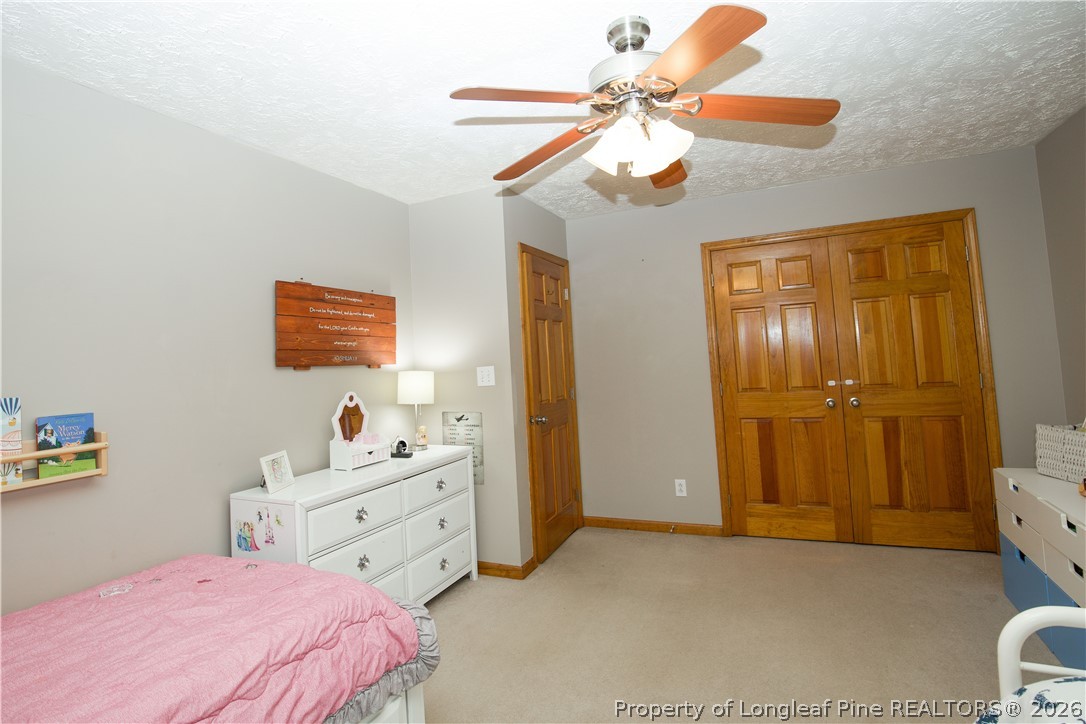 7815 Shuttle Road Fayetteville, NC 28311 - Photo 29 of 50 a spacious bedroom with a bed a dresser and a chandelier