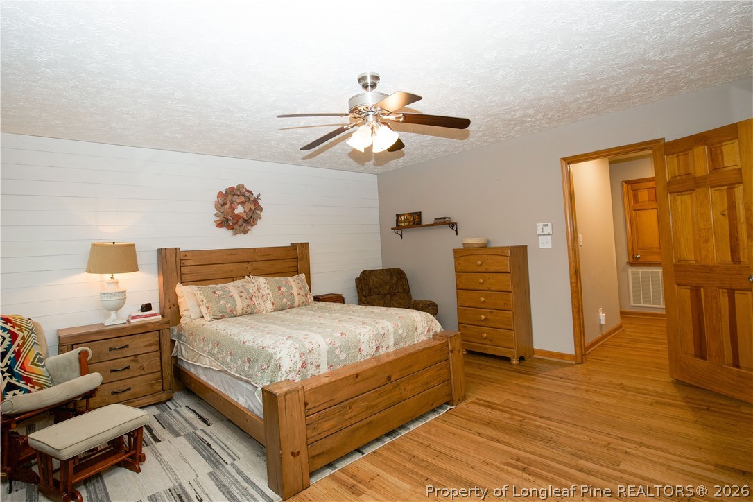 7815 Shuttle Road Fayetteville, NC 28311 - Photo 32 of 50 a bedroom with a bed and wooden floor
