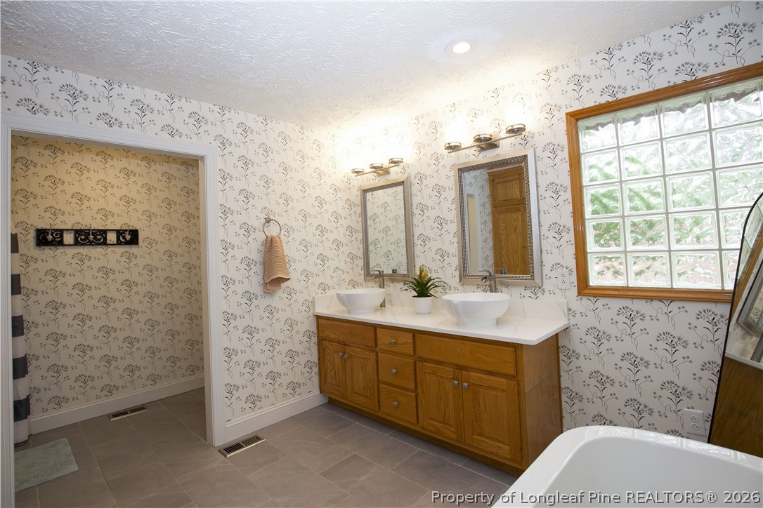 7815 Shuttle Road Fayetteville, NC 28311 - Photo 36 of 50 a bathroom with a double vanity sink toilet mirror and shower