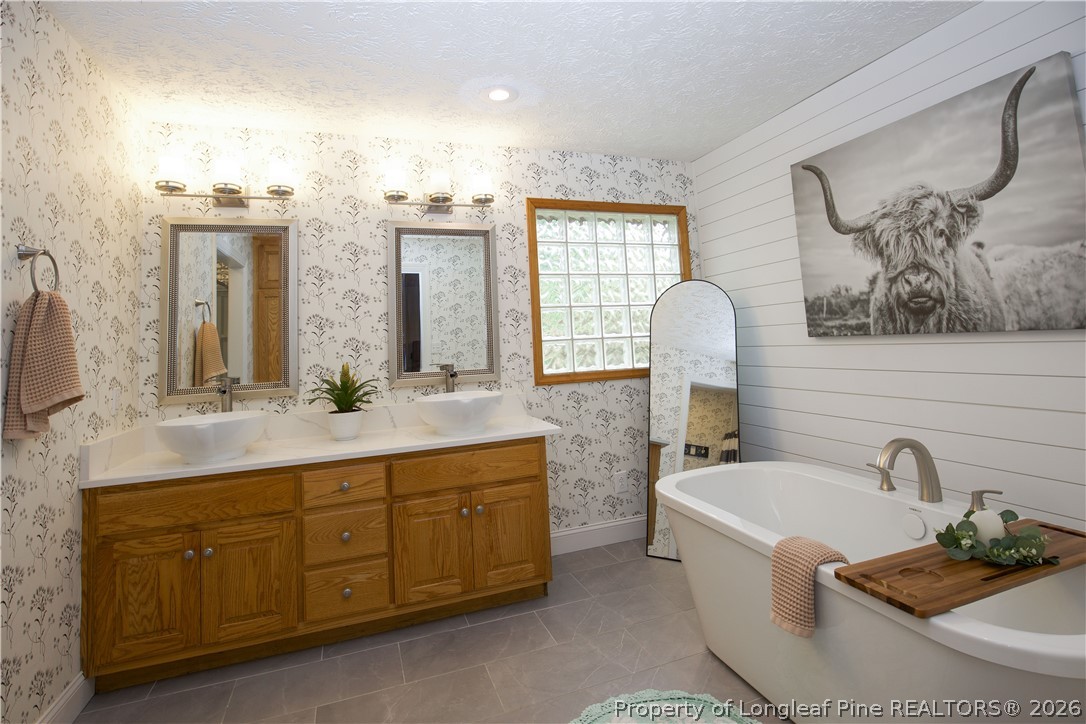 7815 Shuttle Road Fayetteville, NC 28311 - Photo 37 of 50 a bathroom with a tub sink and mirror