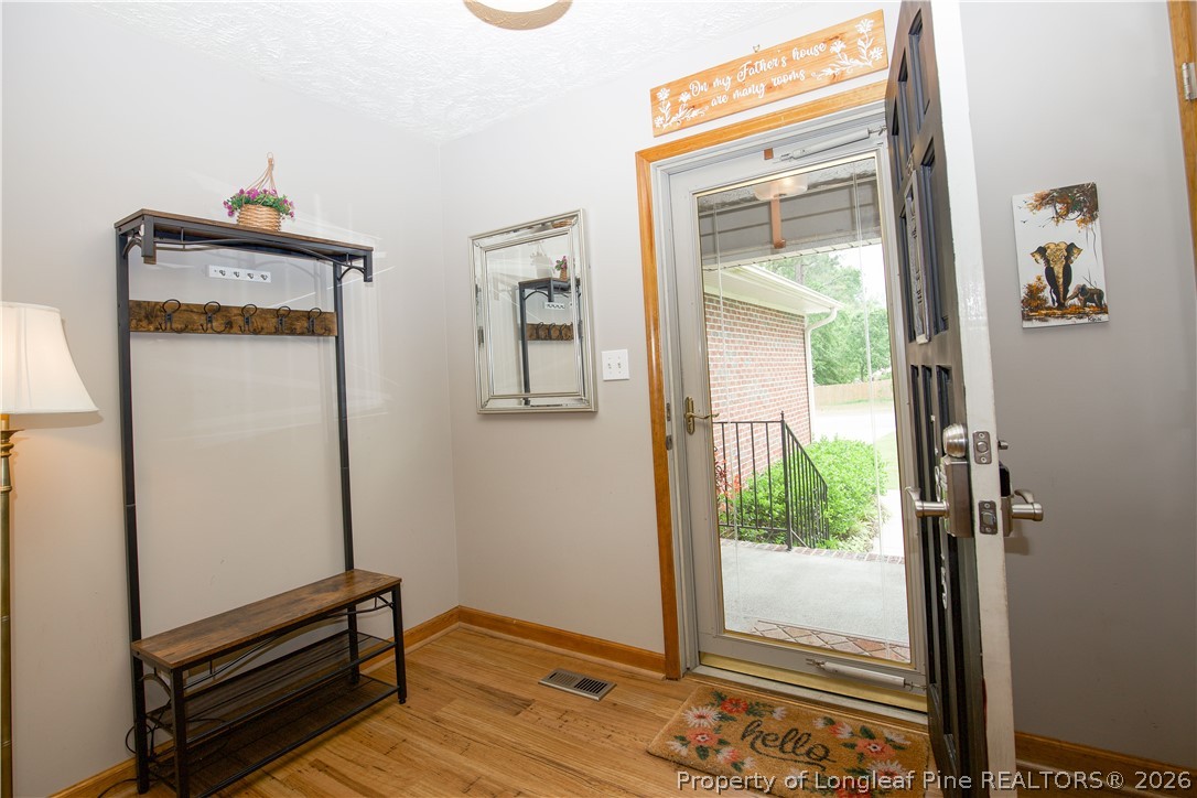 7815 Shuttle Road Fayetteville, NC 28311 - Photo 5 of 50 a view of a hallway with wooden floor and a bathroom