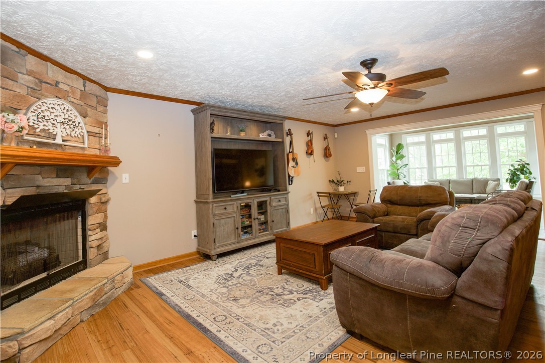 7815 Shuttle Road Fayetteville, NC 28311 - Photo 6 of 50 a living room with furniture a flat screen tv and a fireplace