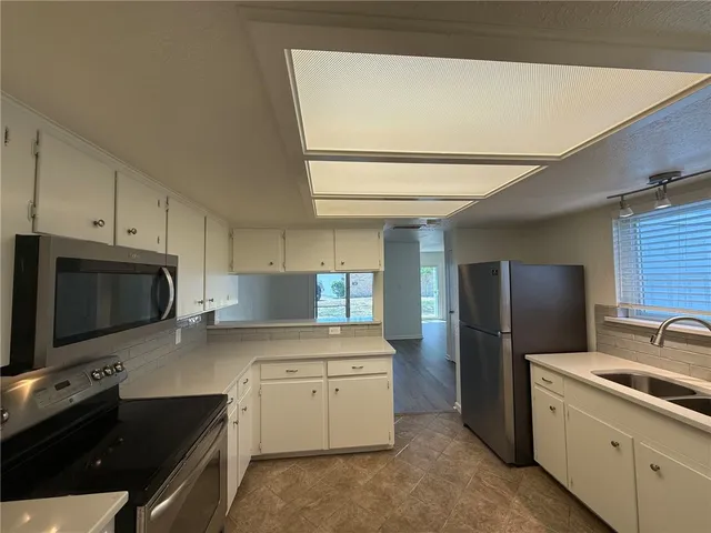 a kitchen with a sink stainless steel appliances and cabinets