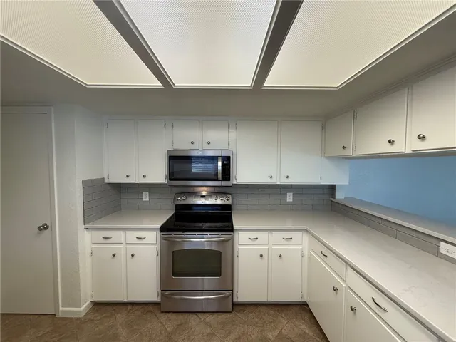 a kitchen with appliances a sink and cabinets