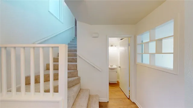 a view of staircase with wooden floor and white walls