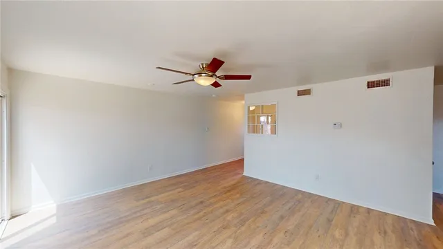a view of empty room with wooden floor