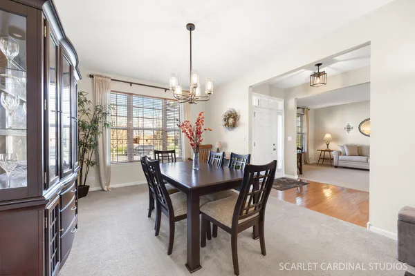 a dining room with stainless steel appliances kitchen island granite countertop a table chairs and a refrigerator