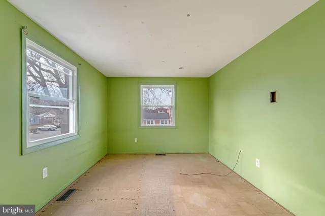 a view of an empty room with closet and a window