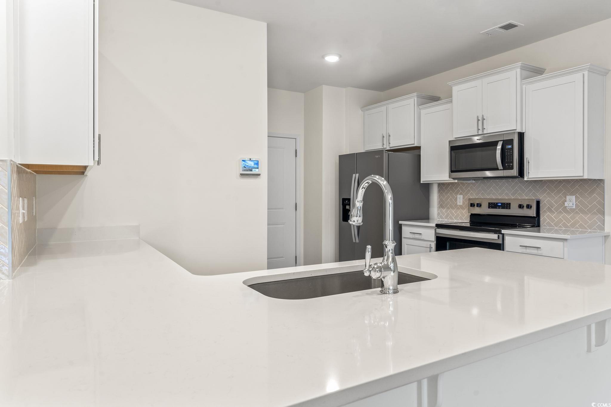 4115 Highway 19 Conway, SC 29526 - Photo 21 of 40 Clean view of the solid white granite countertops and large undermount sink, showcasing the kitchen’s modern design.
