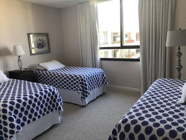 a bedroom with bed and two window