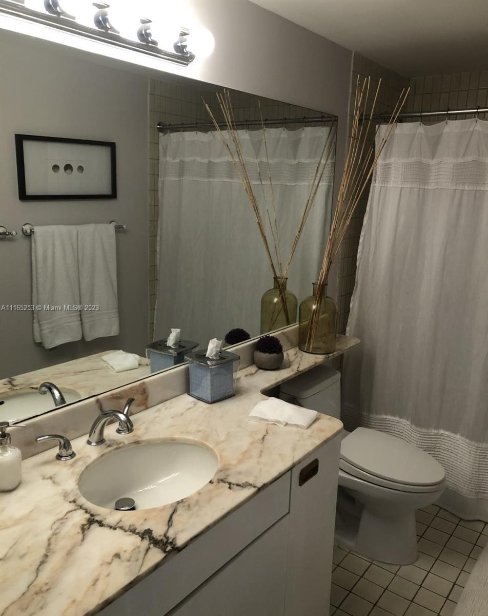 101 Crandon Boulevard, Unit 473 Key Biscayne, FL 33149 - Photo 14 of 24 a bathroom with a granite countertop sink toilet and shower