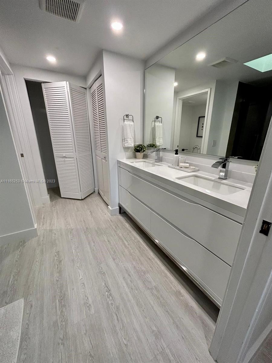 101 Crandon Boulevard, Unit 473 Key Biscayne, FL 33149 - Photo 19 of 24 a bathroom with a double vanity sink and mirror