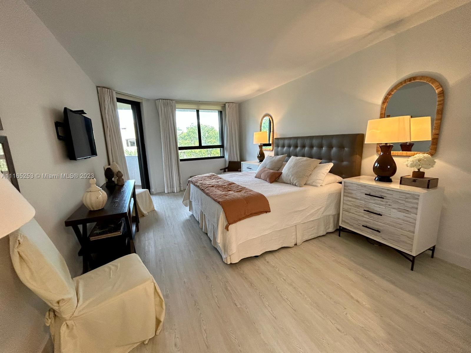 101 Crandon Boulevard, Unit 473 Key Biscayne, FL 33149 - Photo 20 of 24 a bedroom with a bed and wooden floor