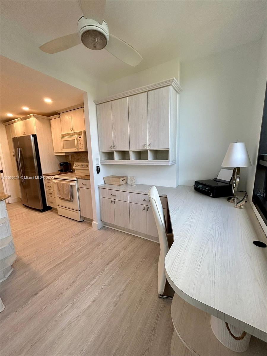 101 Crandon Boulevard, Unit 473 Key Biscayne, FL 33149 - Photo 24 of 24 a kitchen with a stove a sink dishwasher a dining table and chairs with wooden floor
