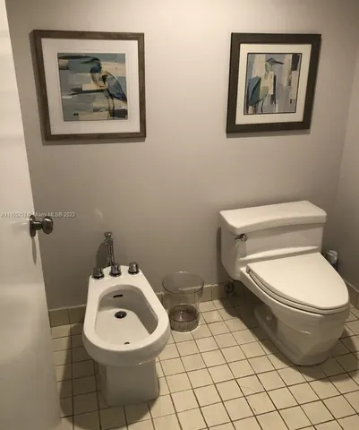 a white toilet sitting next to a white wall