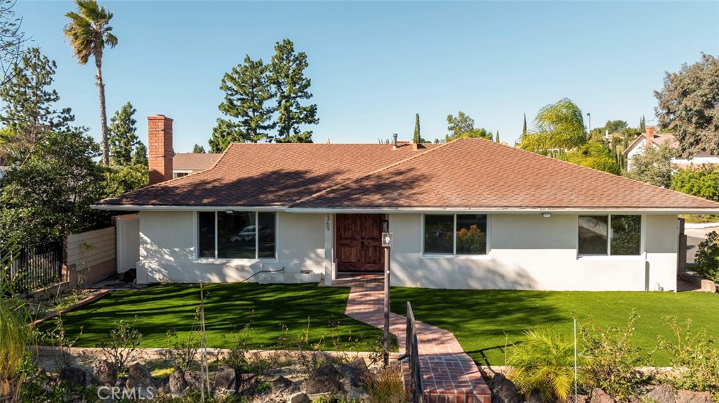 11369 Darby Avenue Porter Ranch, CA 91326 - Photo 2 of 56 a front view of a house with a garden