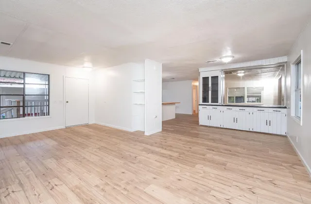 a kitchen with granite countertop a stove and white cabinets with wooden floor