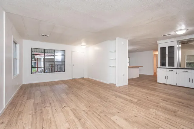 a large kitchen with a lot of counter space and wooden floor