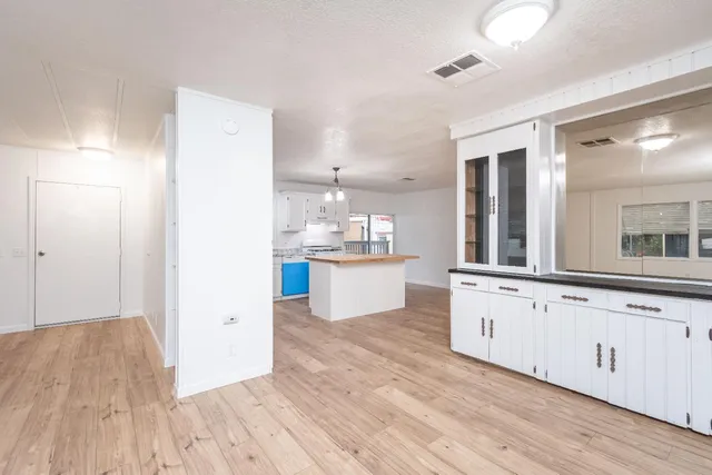 a kitchen with stainless steel appliances granite countertop a refrigerator a stove a sink dishwasher and a refrigerator with wooden floor