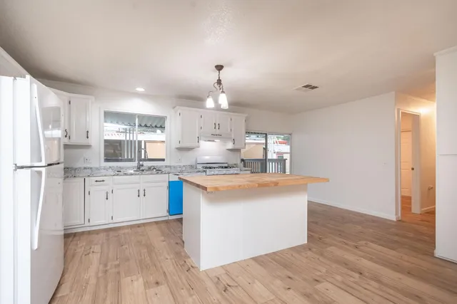 a large kitchen with cabinets and wooden floor