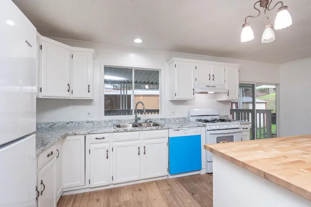 a kitchen with a sink stove top oven and refrigerator