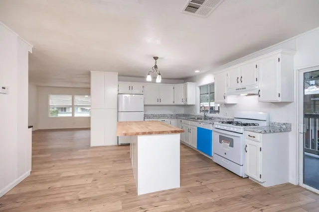 a view of a kitchen with wooden floor and a window