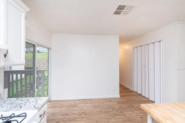 a view of a room with wooden floor and window