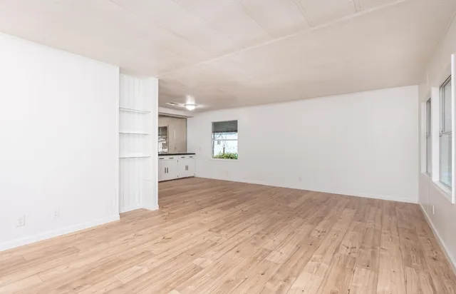 a view of empty room with wooden floor