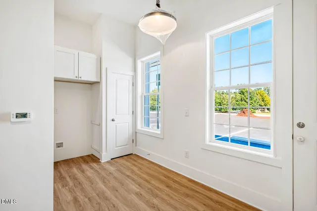 an empty room with a window and wooden floor