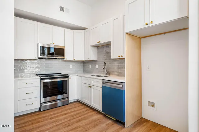 a kitchen with stainless steel appliances granite countertop a stove and a microwave